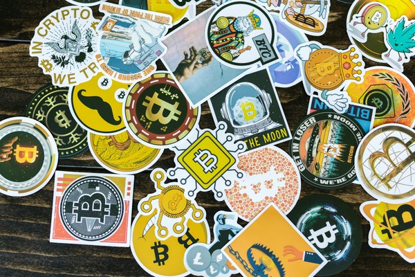 Collection of colorful cryptocurrency-themed stickers scattered on a wooden table