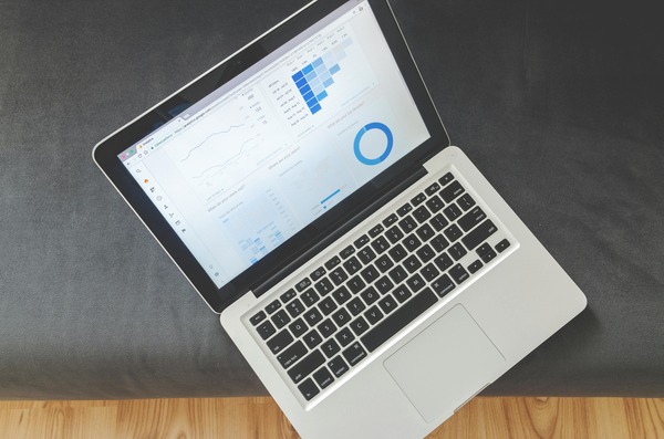 Laptop displaying an analytics dashboard with line and bar charts
